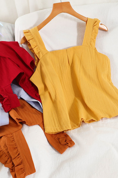 Ühevärviline naiste topp, mille rihmadel on lokid