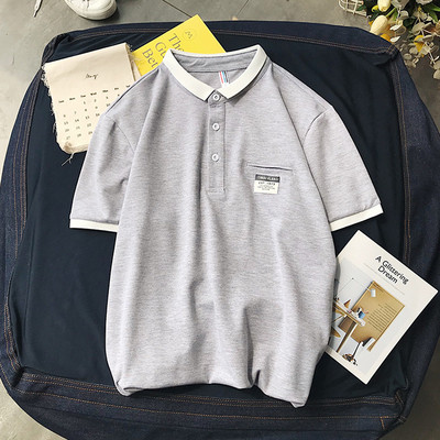 Klassikalise krae ja embleemiga suvine pluus