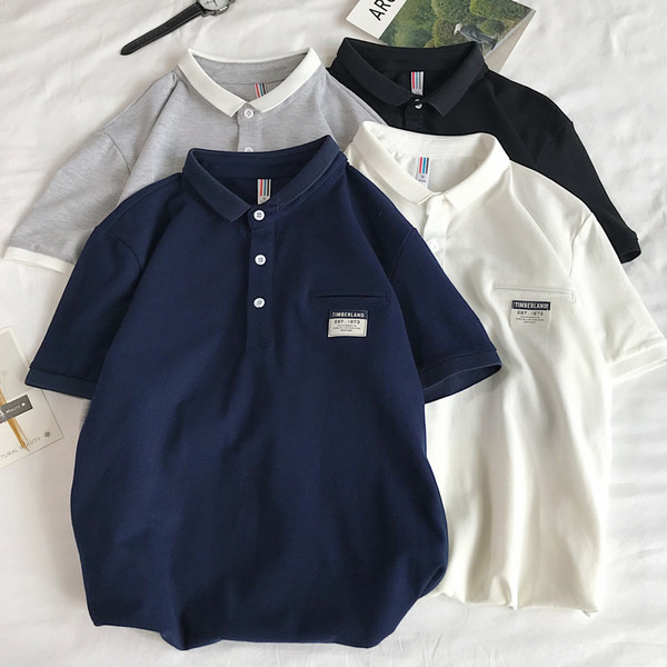 Klassikalise krae ja embleemiga suvine pluus