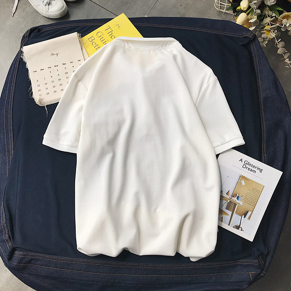 Klassikalise krae ja embleemiga suvine pluus