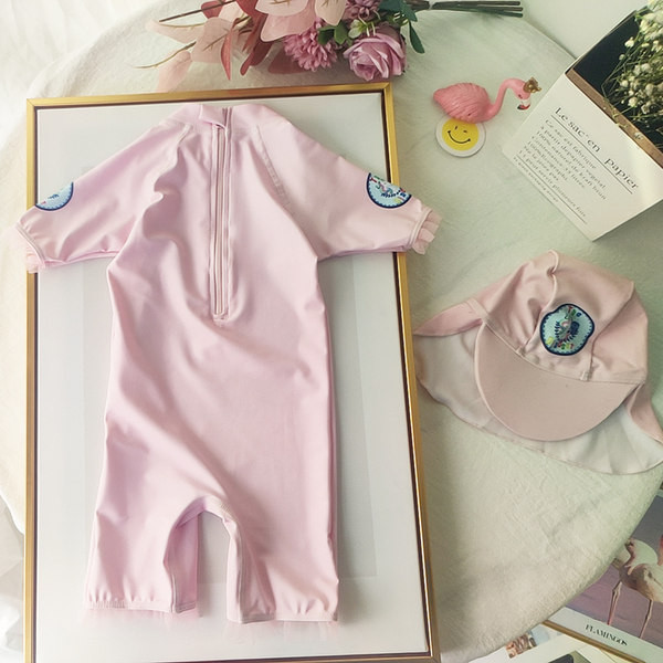 Värvilise aplikatsiooniga roosat värvi laste ujumistrikoo, mis sobib tüdrukutele