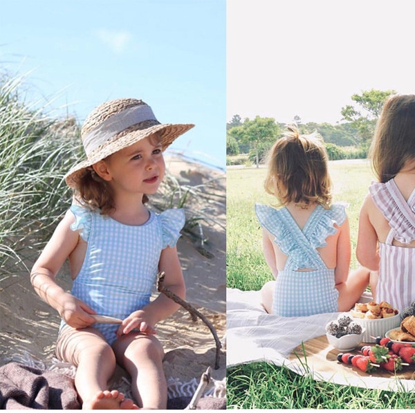 Laste ujumistrikoo seljas ristrihmadega ja lokkidega