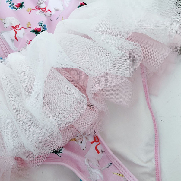 Laste ujumistrikoo pikkade varrukatega ja pitsaseelikuga