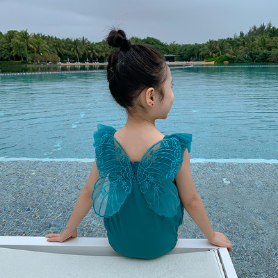 Roheline laste ujumistrikoo, millel on seljal 3D tiivad