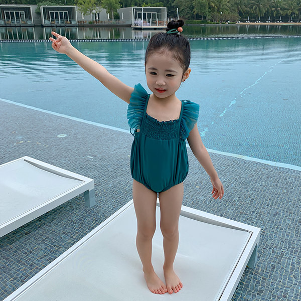 Roheline laste ujumistrikoo, millel on seljal 3D tiivad