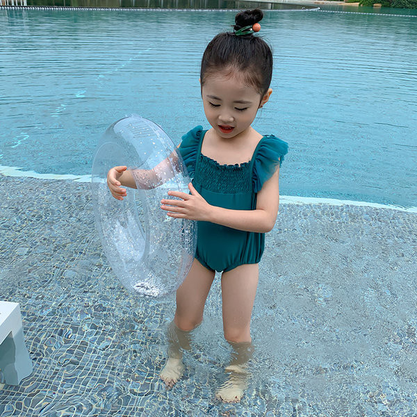 Roheline laste ujumistrikoo, millel on seljal 3D tiivad