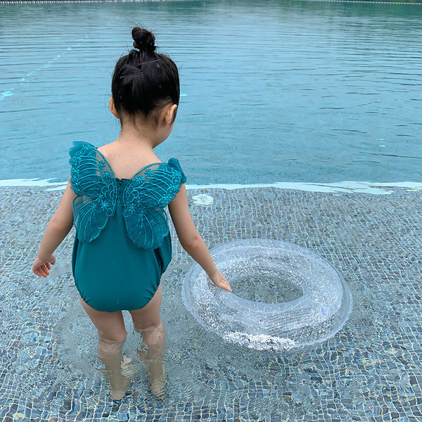 Roheline laste ujumistrikoo, millel on seljal 3D tiivad