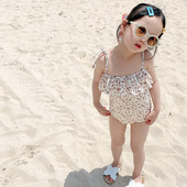 Terve peenikeste rihmade ja lokkidega laste ujumistrikoo