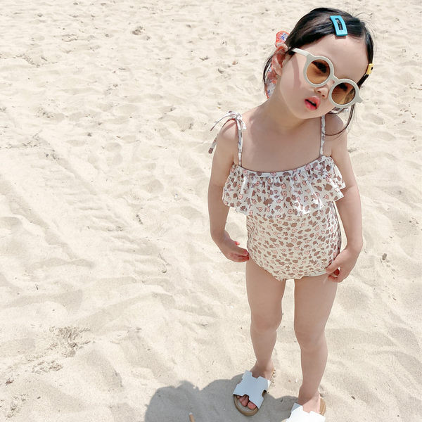 Terve peenikeste rihmade ja lokkidega laste ujumistrikoo