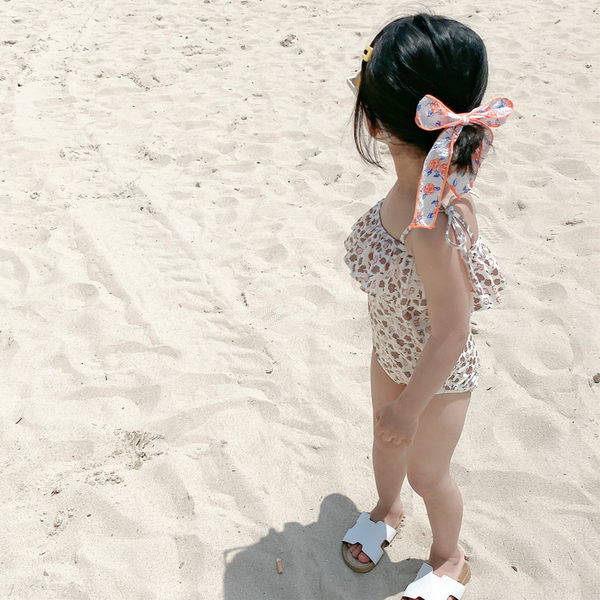 Terve peenikeste rihmade ja lokkidega laste ujumistrikoo