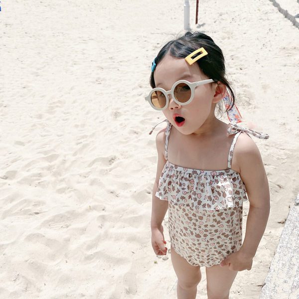 Terve peenikeste rihmade ja lokkidega laste ujumistrikoo