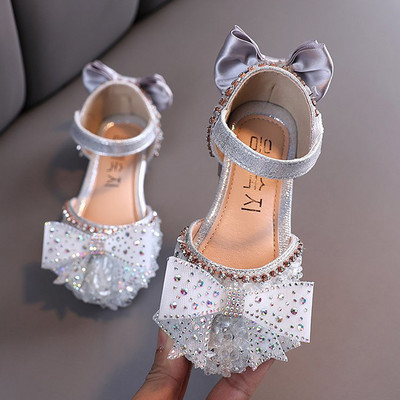 Laste stiilsed kingad, millel on teibi ja dekoratiivkividega paelkinnitus