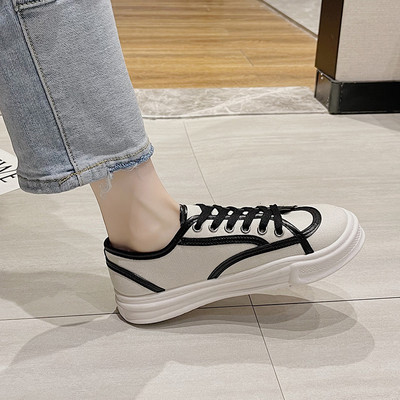 Naiste valged ja mustad tossud paelte ja lameda tallaga