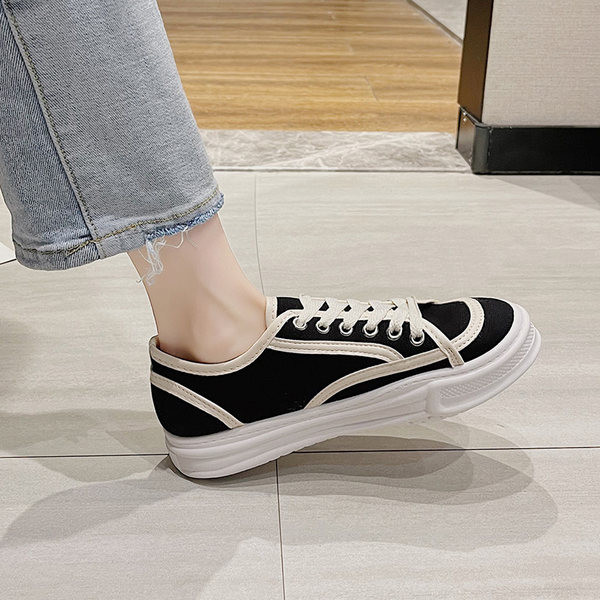 Naiste valged ja mustad tossud paelte ja lameda tallaga