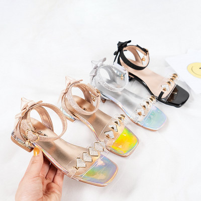 Modern children`s sandals for girls with metal buckle, ribbons and metal decoration