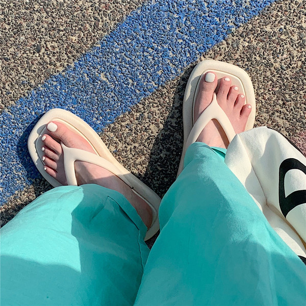 Sieviešu gumijas flip-flops virs pludmales