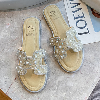 Aktuālās sieviešu čības ar dekoratīvām pērlēm un plakanu zoli