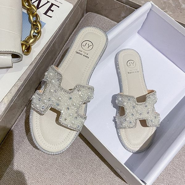 Aktuālās sieviešu čības ar dekoratīvām pērlēm un plakanu zoli