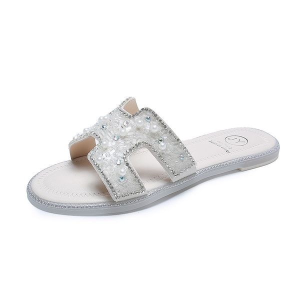 Aktuālās sieviešu čības ar dekoratīvām pērlēm un plakanu zoli