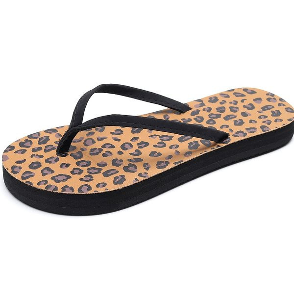 Sieviešu flip flops pāri purngalam uz plakanas zoles, kas piemērota pludmalei