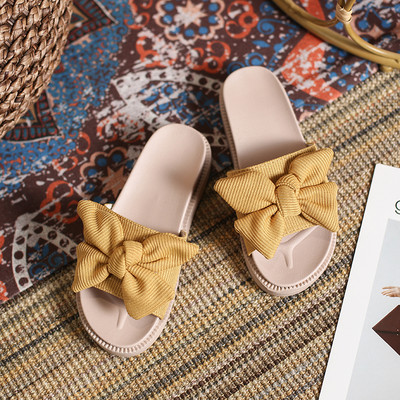 Γυναικείες παντόφλες με επίπεδη σόλα και κορδέλα