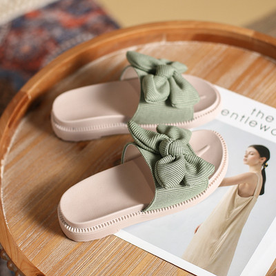 Γυναικείες παντόφλες με επίπεδη σόλα και κορδέλα