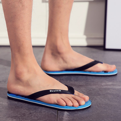Vasaras vīriešu flip-flops starp pirkstiem