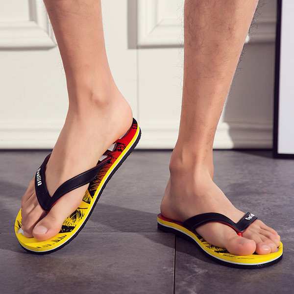 Vasaras vīriešu flip-flops starp pirkstiem