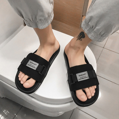 Vīriešu tekstila čības ar emblēmu un plakanu zoli