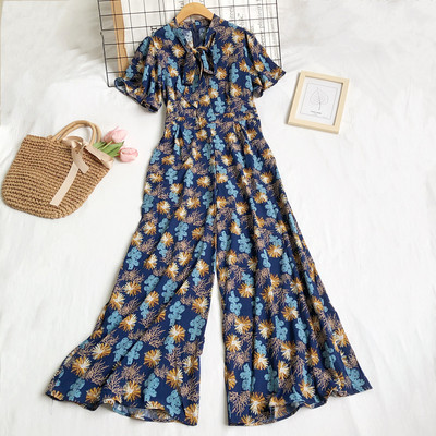 Garš sieviešu kombinezons ar ziedu motīviem un rāvējslēdzēju