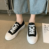 Modernas sieviešu kedas ar mežģīnēm un plakanu zoli baltā un melnā krāsā