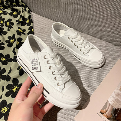 Modernas sieviešu kedas ar mežģīnēm un plakanu zoli baltā un melnā krāsā