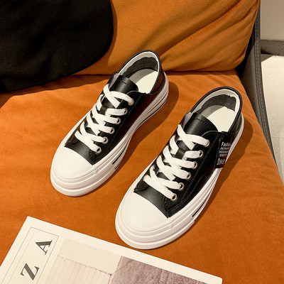 Modernas sieviešu kedas ar mežģīnēm un plakanu zoli baltā un melnā krāsā