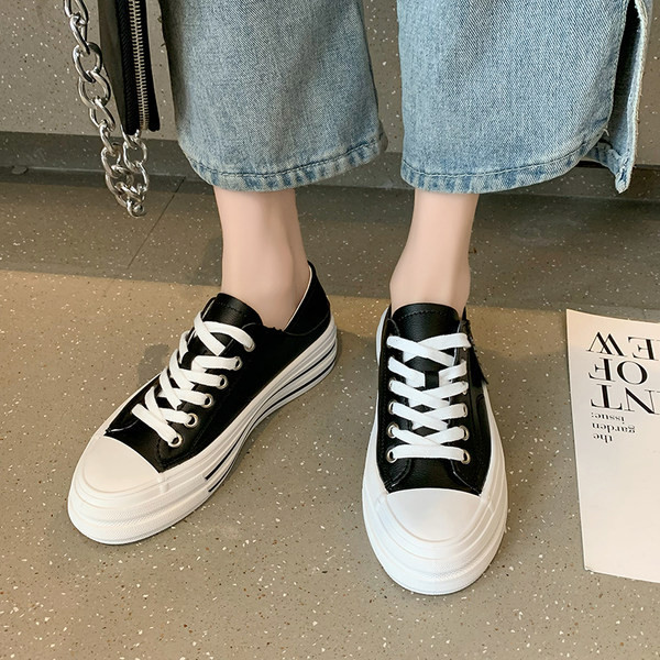 Modernas sieviešu kedas ar mežģīnēm un plakanu zoli baltā un melnā krāsā