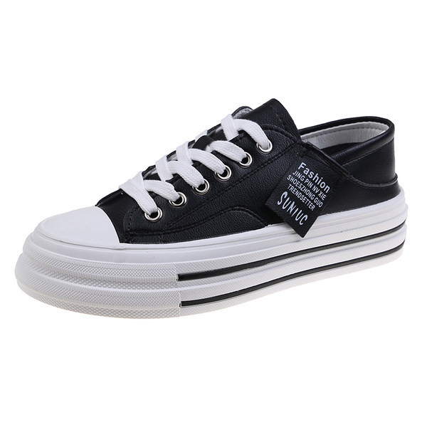 Modernas sieviešu kedas ar mežģīnēm un plakanu zoli baltā un melnā krāsā