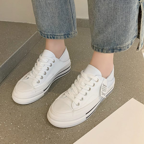 Modernas sieviešu kedas ar mežģīnēm un plakanu zoli baltā un melnā krāsā