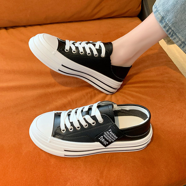 Modernas sieviešu kedas ar mežģīnēm un plakanu zoli baltā un melnā krāsā