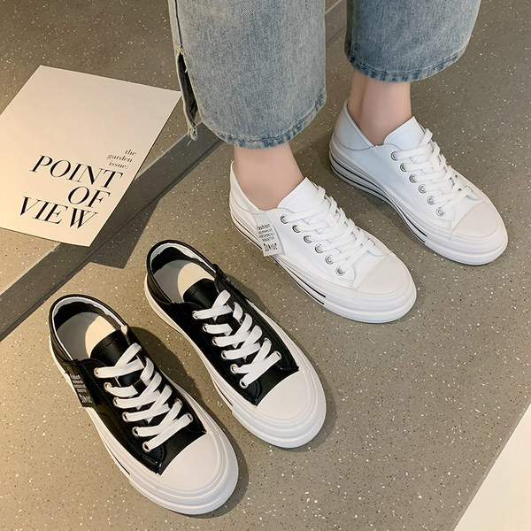 Modernas sieviešu kedas ar mežģīnēm un plakanu zoli baltā un melnā krāsā