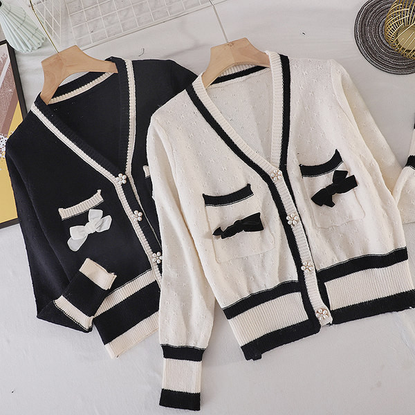 Női kardigán zsebekkel és fehér és fekete szalaggal