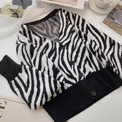 Kötött mellény gombokkal és spitz nyakkivágással