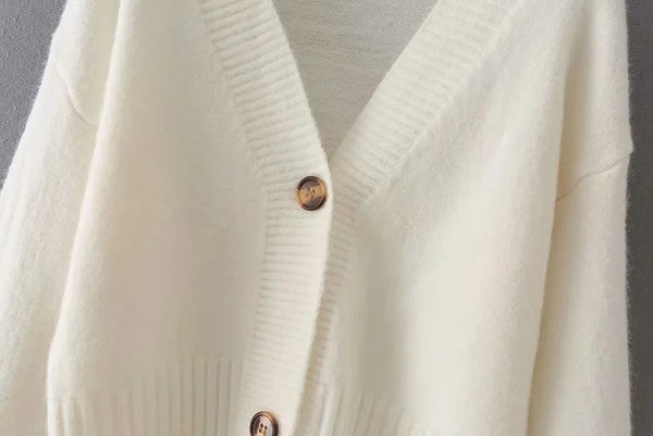 Lühike sügisvest nööpide ja sügava spitsikaelusega