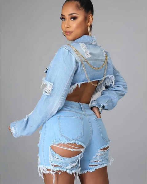 Modern női rövid farmerdzseki szakadt motívumokkal és fémlánccal