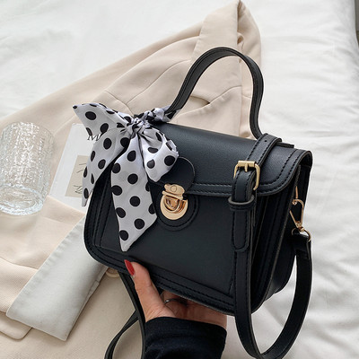 Női bőrtáska két füllel és szalaggal