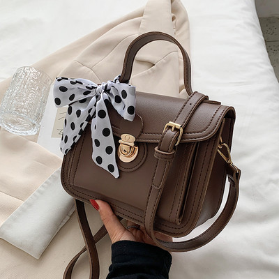 Női bőrtáska két füllel és szalaggal