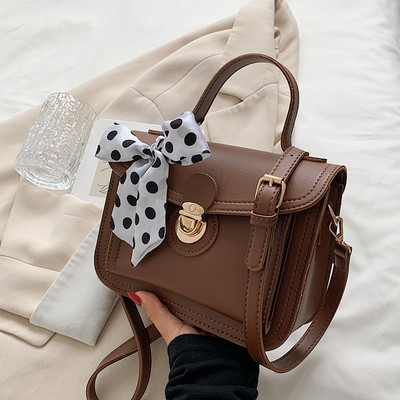 Női bőrtáska két füllel és szalaggal