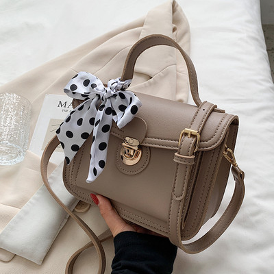 Női bőrtáska két füllel és szalaggal