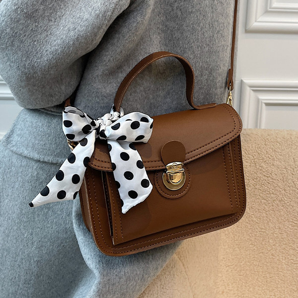 Női bőrtáska két füllel és szalaggal