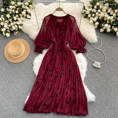 Moteriška ilga suknelė su gėlių raštu ir kaspinu