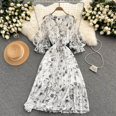 Moteriška ilga suknelė su gėlių raštu ir kaspinu