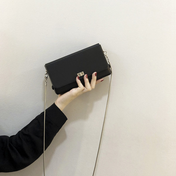 Moderna mala torbica s dugom metalnom ručkom